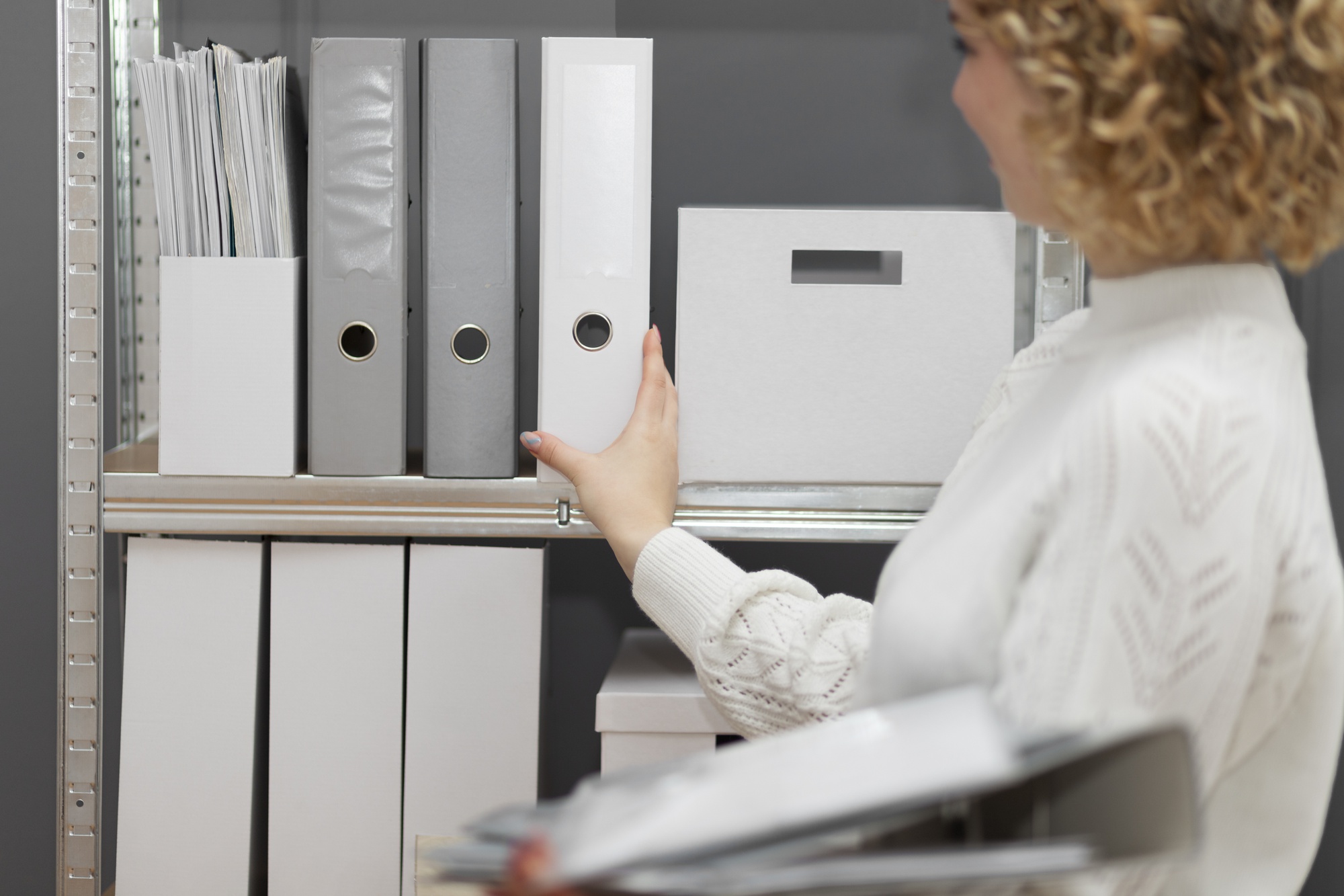 Collaboratrice classant des dossiers et documents administratifs dans un bureau