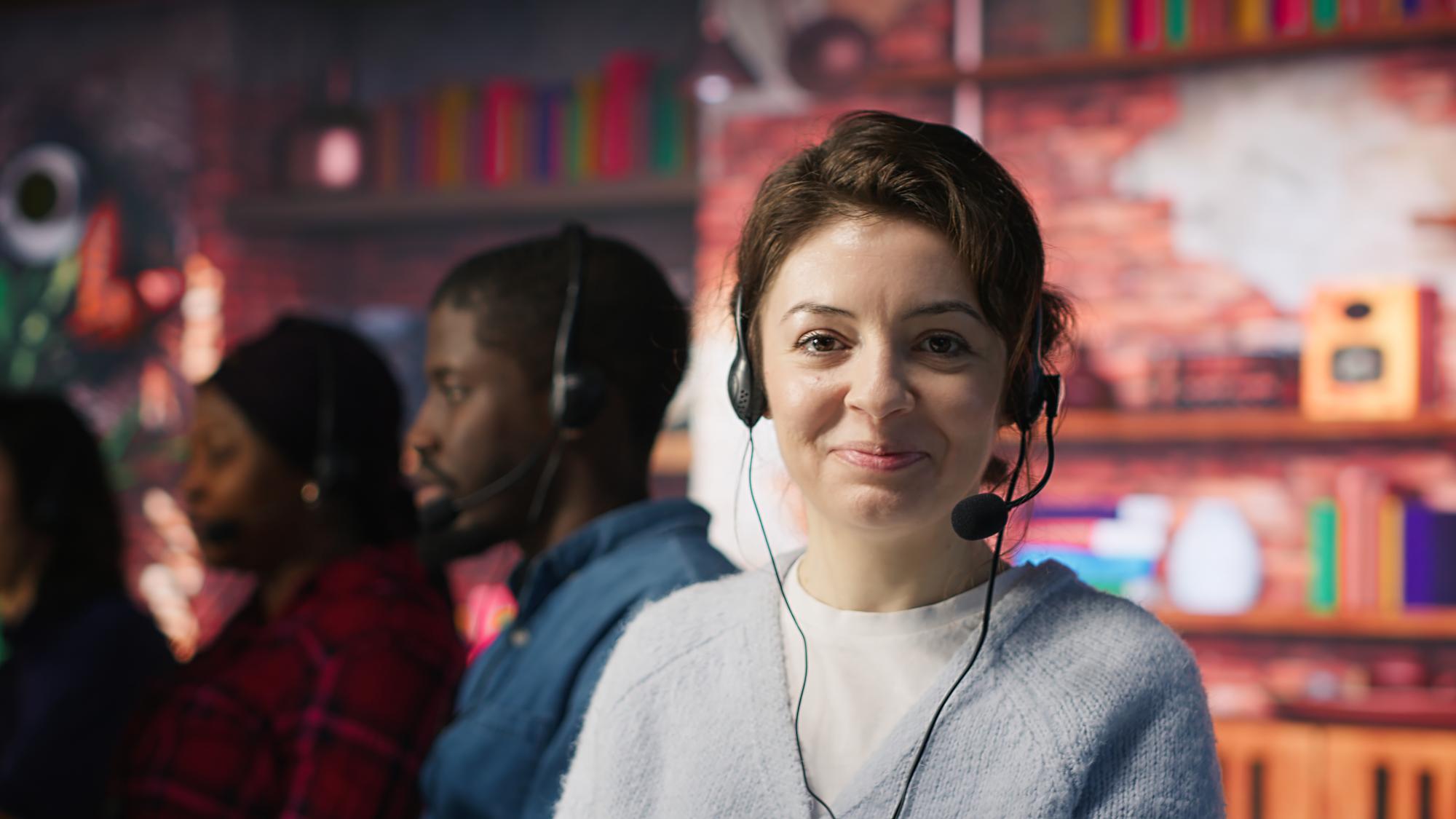 Conseillère clientèle avec casque-micro au sein d'une équipe support